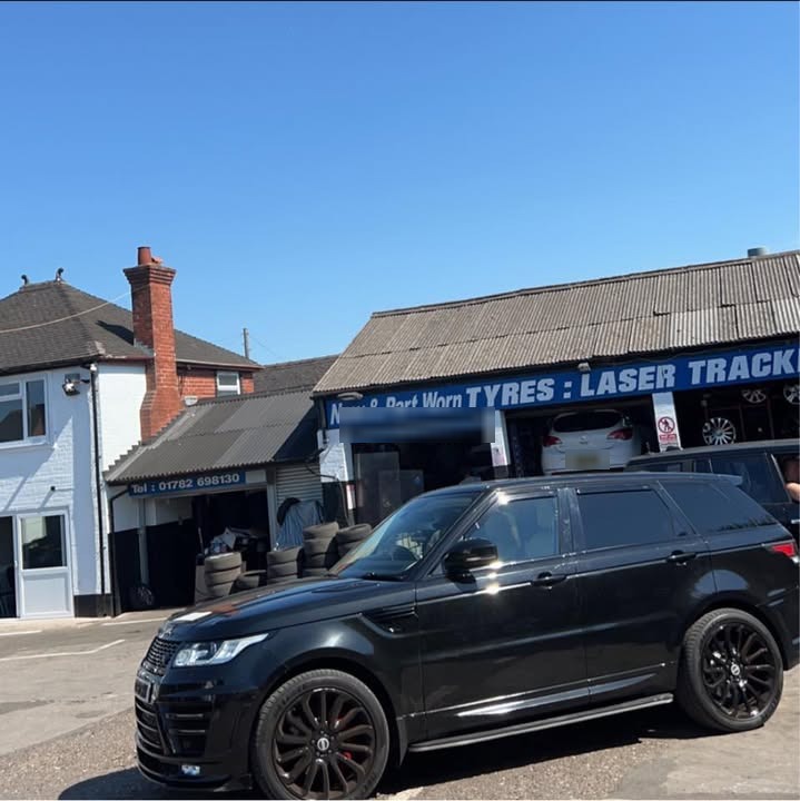 A black Range Rover on the forecourt outside the Stoke Tyres bays