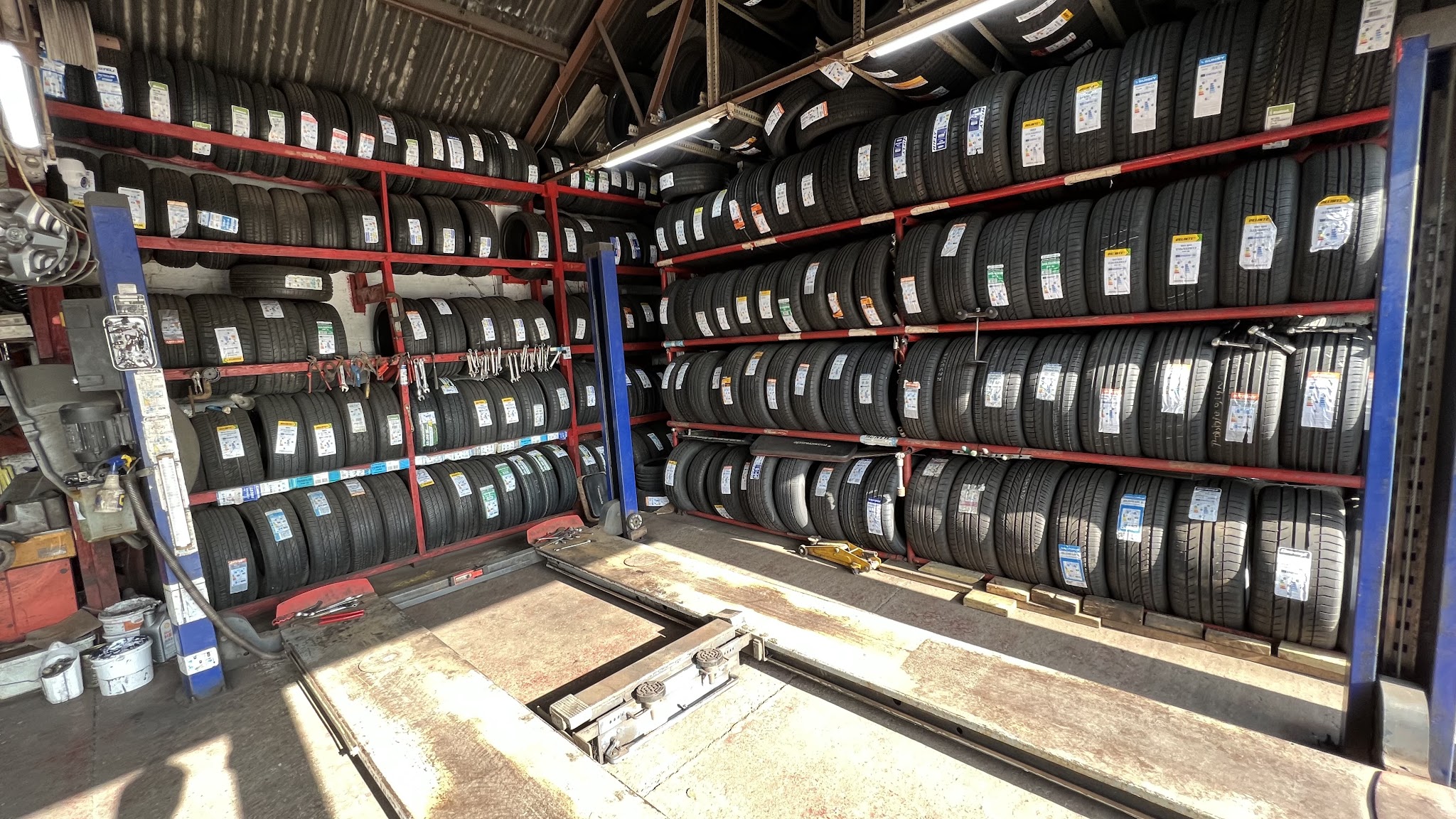 A wall of racked new tyres inside the workshop